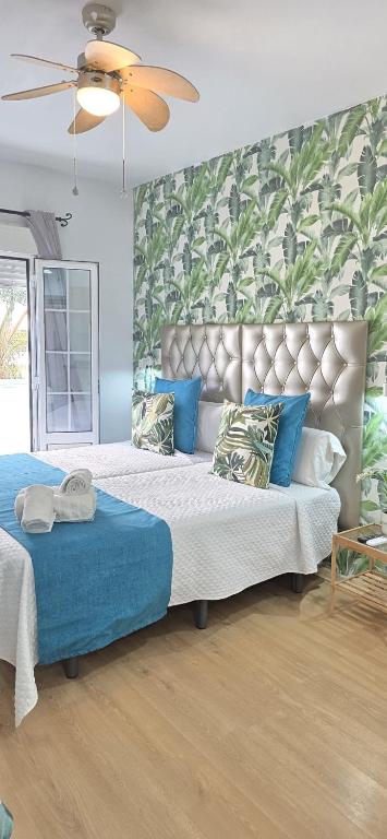 a bedroom with a large bed with blue pillows at Candisol Cozy Inns in Torremolinos