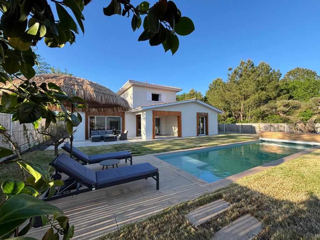 a backyard with a swimming pool and a house at Villa Karasse in Lège-Cap-Ferret
