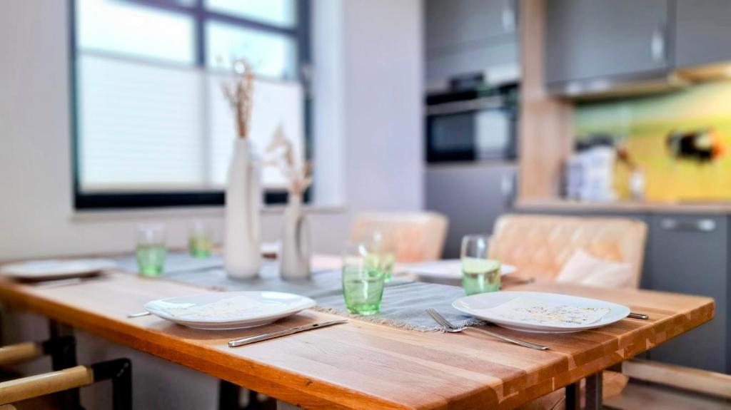 a wooden table with plates and utensils on it at CBlue "Zickerstuuv", Wasserblick, in der Natur, Grill in Groß Zicker