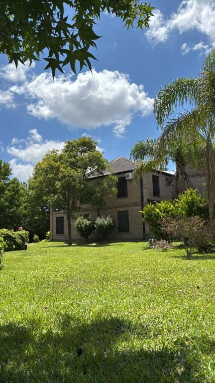 ein Haus mit einem Garten mit grünem Gras und Bäumen in der Unterkunft Los Alerces in Villa Urquiza