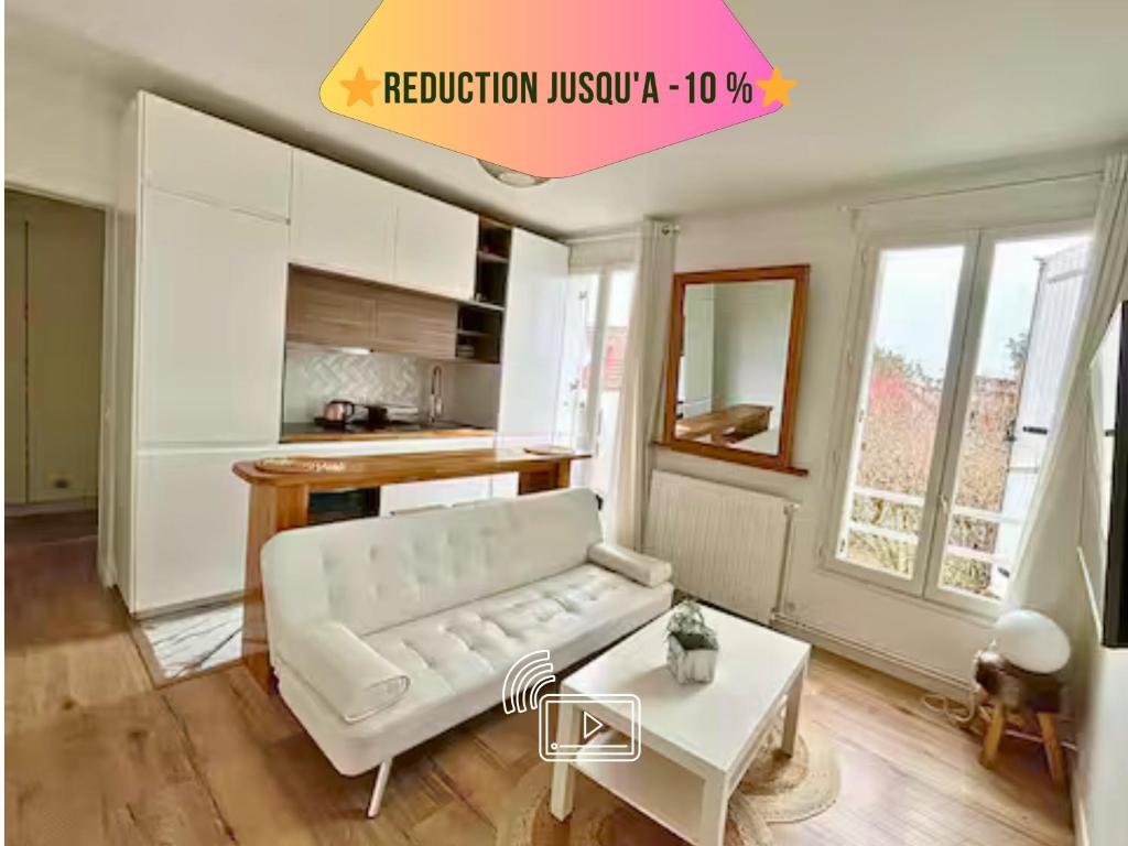 a living room with a white couch and a table at Escapade à 2 ou en petit groupe Appartement tout équipé Quartier résidentiel calme RER direct Parfait pour télétravail et détente in Saint-Maur-des-Fossés