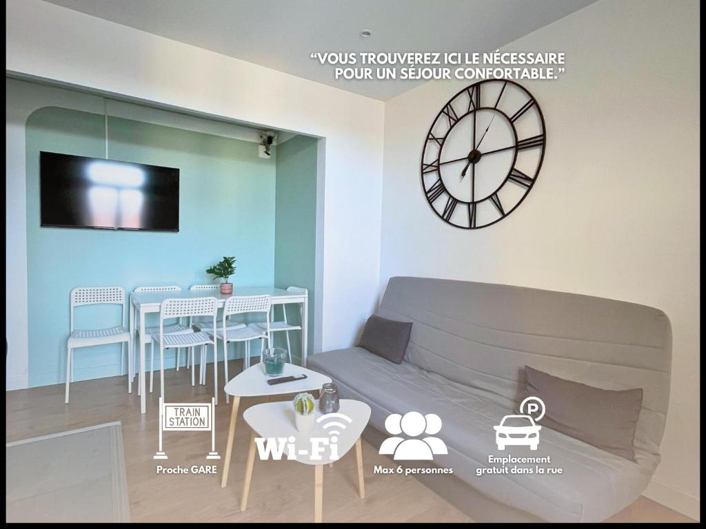 een kamer met een bed en een klok aan de muur bij SQ Appart-ment in Saint-Quentin