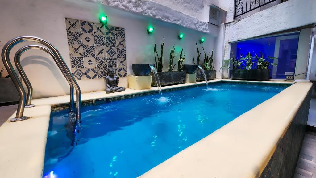 a large pool with blue water in a bathroom at Hotel Casa del Hidalgo Centenario - Business & Leisure in Cali