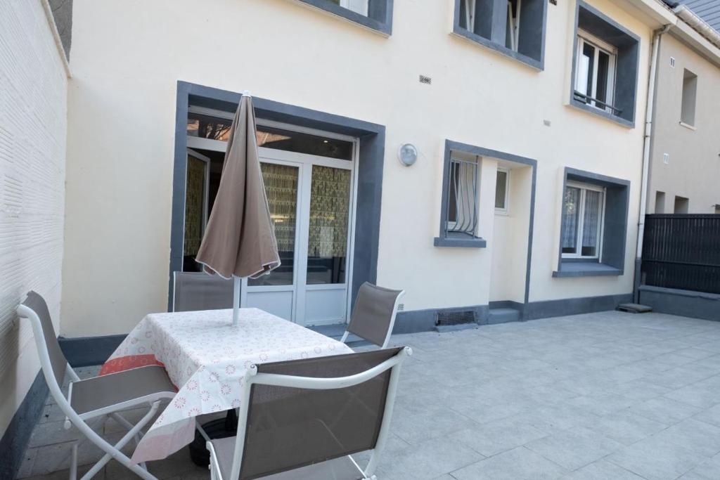 un patio avec une table et un parasol dans l'établissement Albatros du Portel, à Le Portel