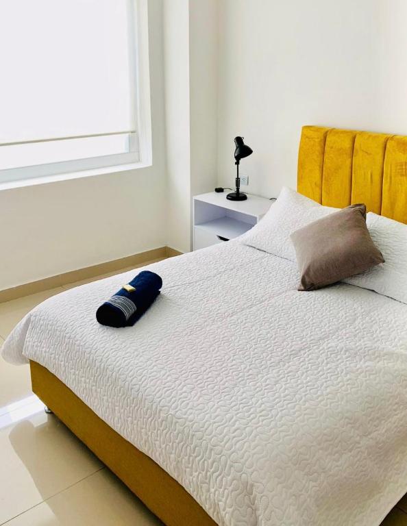 a bed with a blue pillow on it in a bedroom at CasaColibri in Pasto