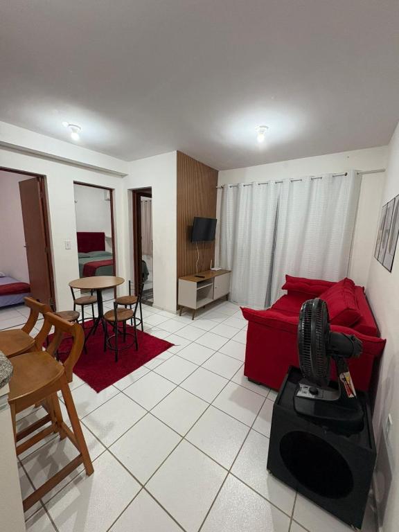 a living room with a red couch and a table at APT Bela Cintra PRIME 3 km da praia do Aracagy in São Luís