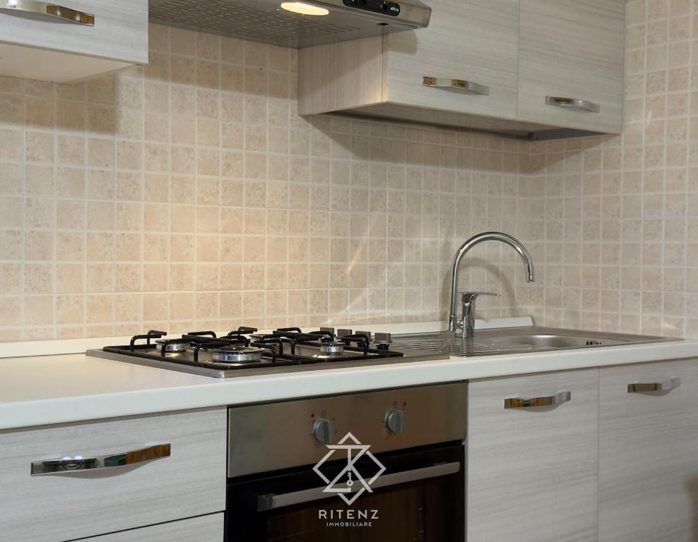 a kitchen with a stove and a sink at Domus Aurora in Villasimius