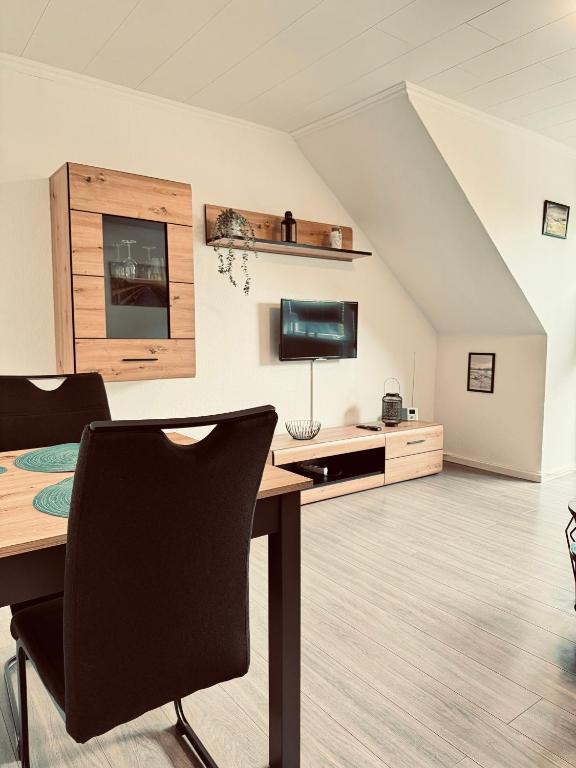 an attic office with a desk and a tv at Apartment 4 - Haus Heinke am Deich in Friedrichskoog