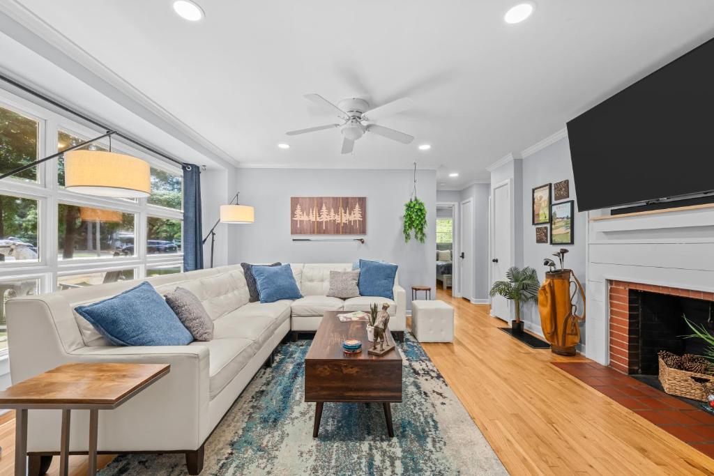 a living room with a white couch and a fireplace at New Owners! Downtown Corner Cottage-Pet Friendly in Southern Pines