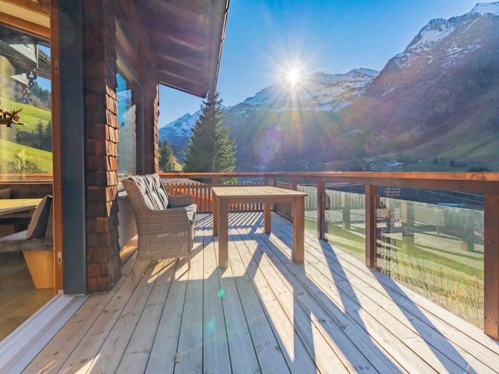 a wooden deck with a table and bench on a balcony at Spykerhütte in Rauris
