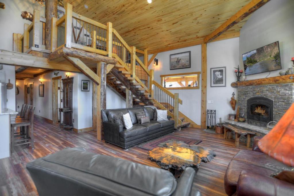 a living room with a couch and a fireplace at Homestake Cabin in Creede