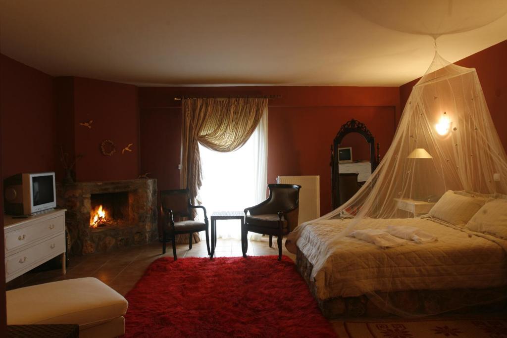 a bedroom with a bed and a fireplace and a window at Aloni Toy Kir Thanasi Hotel & Spa in Volakas