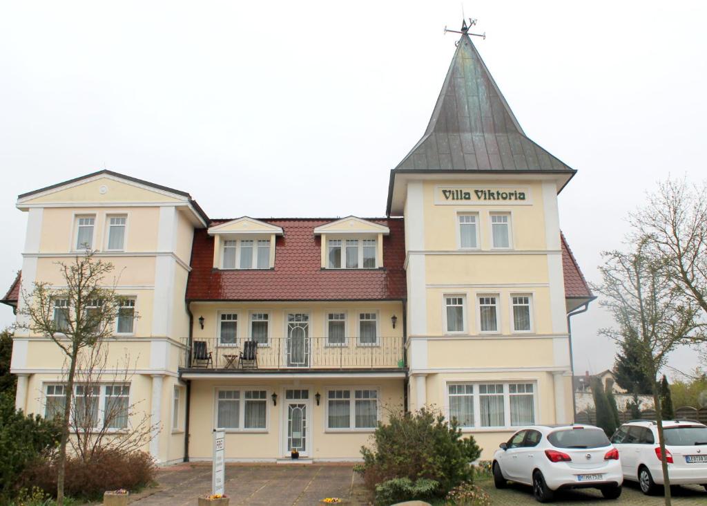 ein großes weißes Gebäude mit einem Turm oben in der Unterkunft Villa Viktoria auf Usedom in Ostseebad Kölpinsee