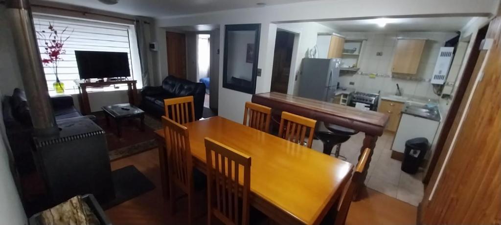 een woonkamer met een houten tafel en een keuken bij Alquiler House in Puerto Montt