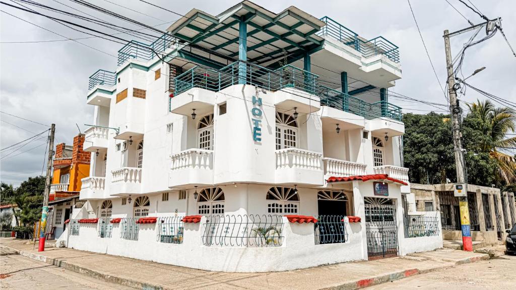 a white building with a balcony on a street at Hotel Santiago de Tolú in Santiago