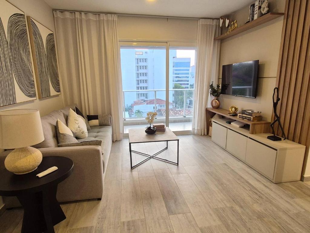 un salon avec un canapé et une télévision dans l'établissement Apartamento Zona Paseo La Galera, à Asuncion