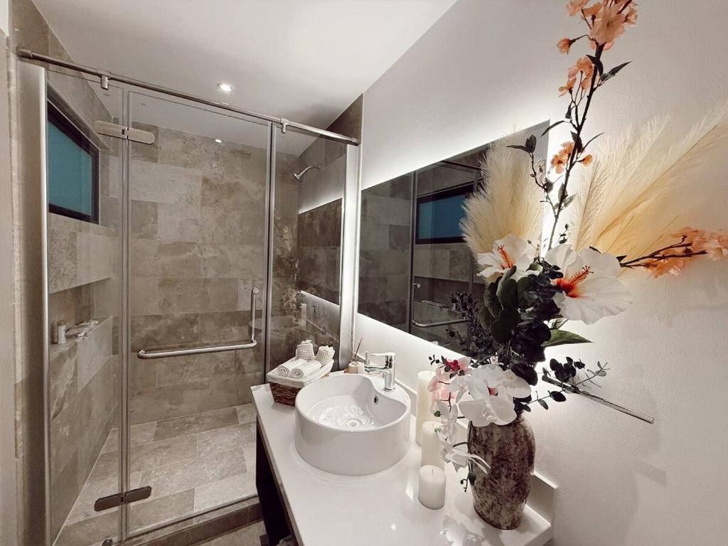 a bathroom with a sink and a glass shower at Ipana Luxury by Felix in Playa del Carmen