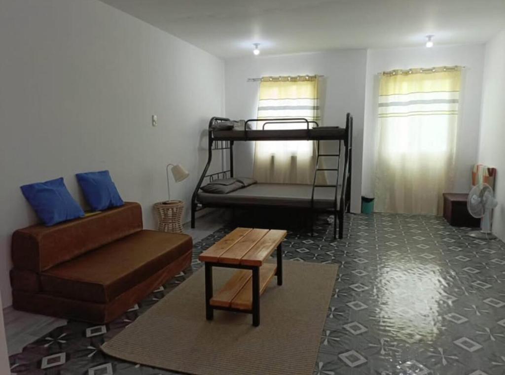 a living room with a couch and a bunk bed at Townhouse in Compostela Cebu in Compostela