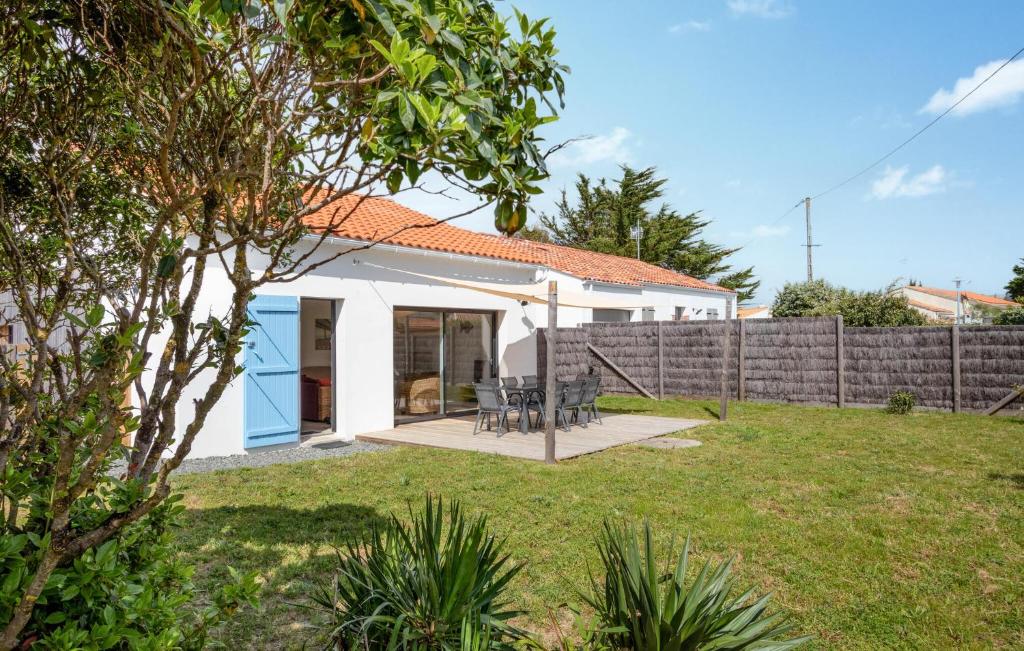 a white house with a fence and a yard at Charmante Maison Proche Mer in Notre-Dame-de-Monts
