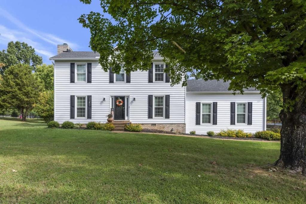 a white house with a tree in the yard at Private Neighborhood Getaway - Big Backyard & Game Room in Cedar Grove