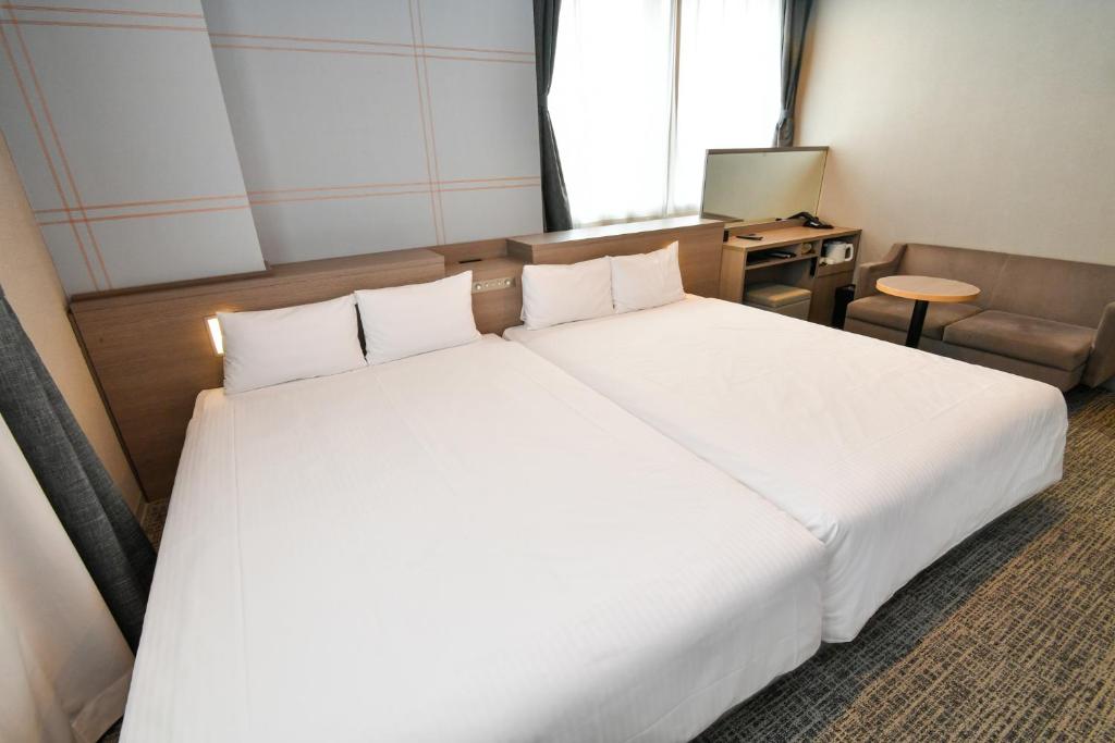 เตียงในห้องที่ Sanco Inn Nagoya Shinkansen-guchi Annex