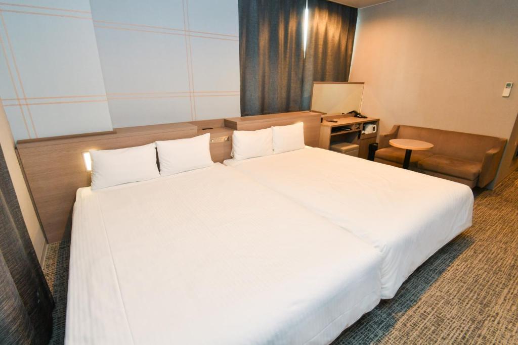 เตียงในห้องที่ Sanco Inn Nagoya Shinkansen-guchi Annex