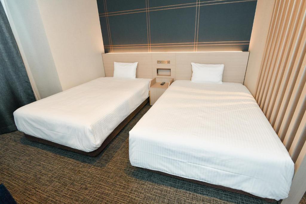 เตียงในห้องที่ Sanco Inn Nagoya Shinkansen-guchi Annex