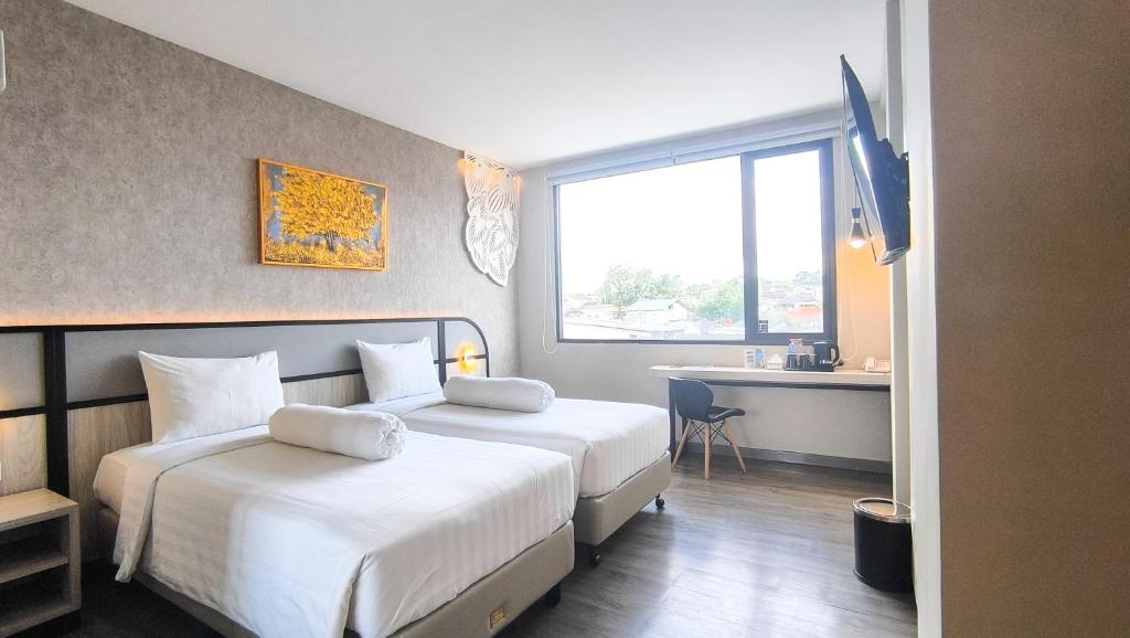 Postel nebo postele na pokoji v ubytování Front One Gosyen Hotel Salatiga