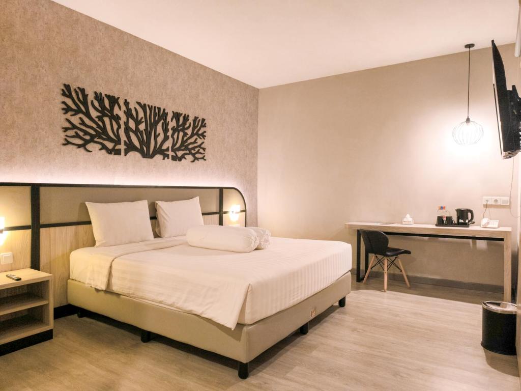 Postel nebo postele na pokoji v ubytování Front One Gosyen Hotel Salatiga