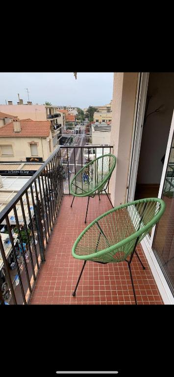 - deux chaises vertes assises au-dessus du balcon dans l'établissement 30 pas et dans l'eau, à Canet