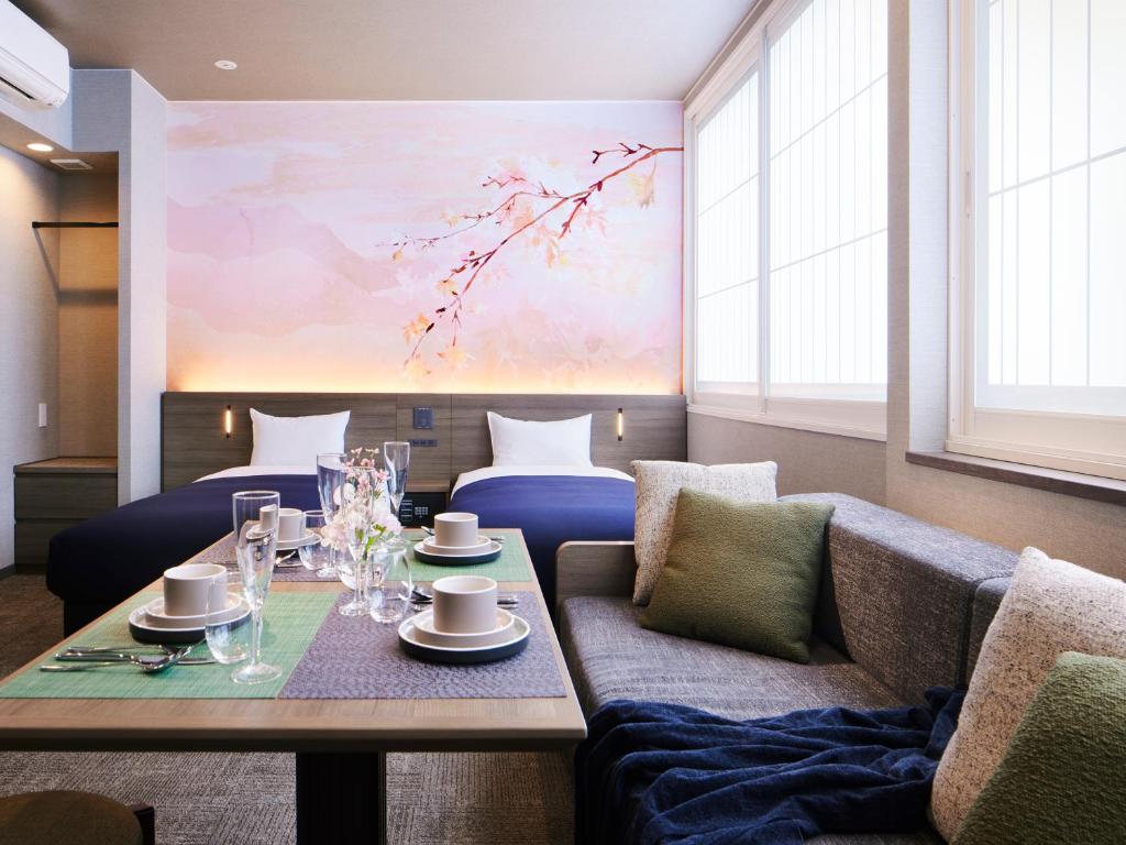 a living room with a table and a couch and a painting at Minn Shijo Omiya in Kyoto