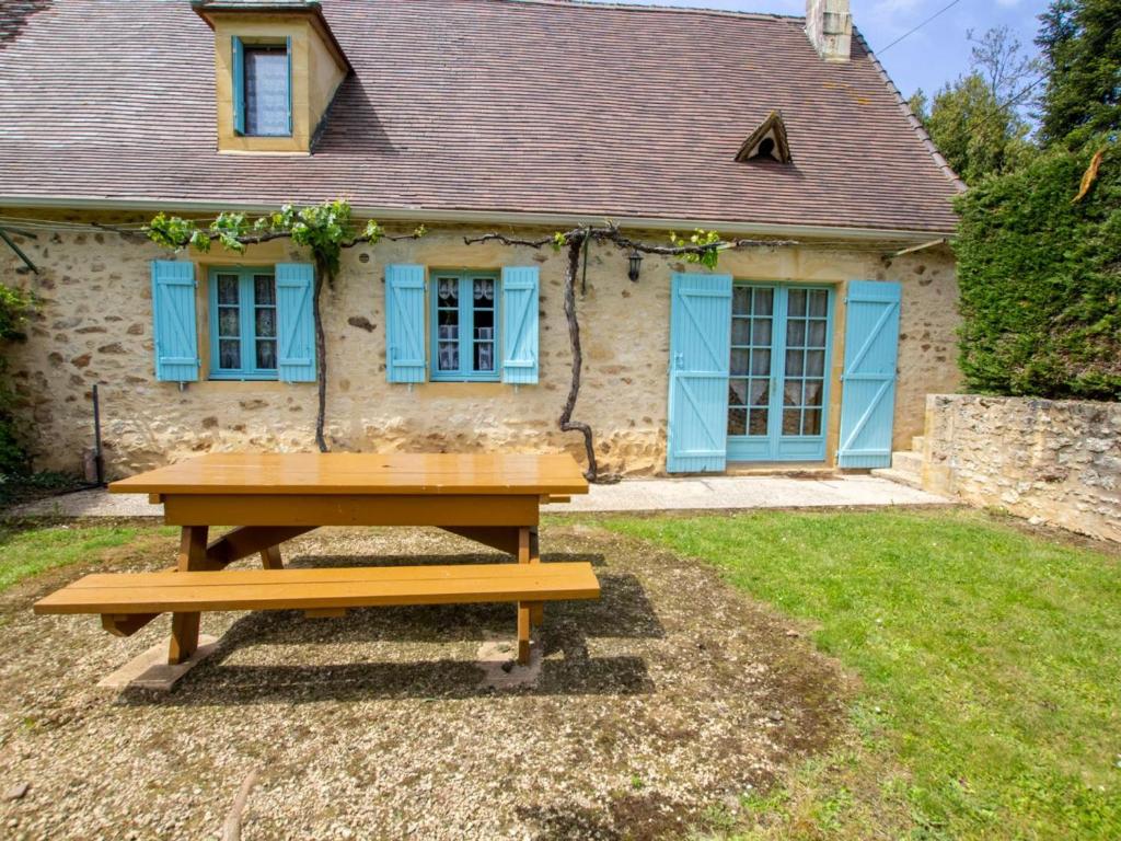 a wooden picnic table in front of a house at Charmante maison Perigord avec parking et cheminée - Saint-Avit-Rivière - FR-1-616-180 in Saint-Avit-Rivière
