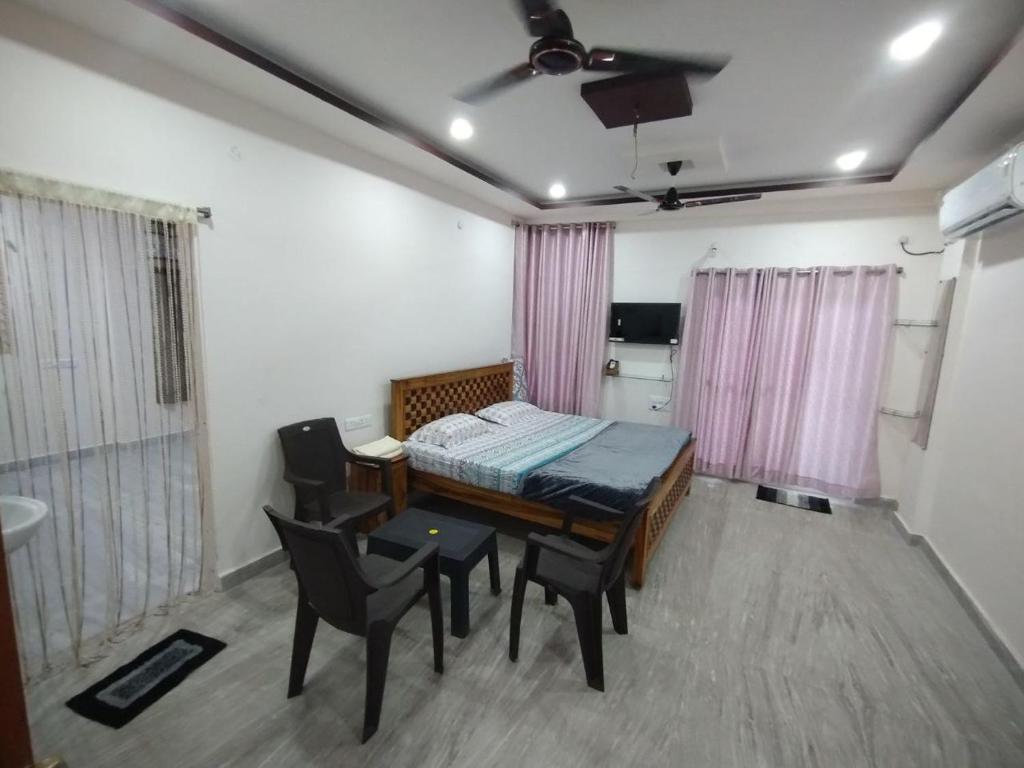 a room with a bed and a table and chairs at KSP Homes in Visakhapatnam