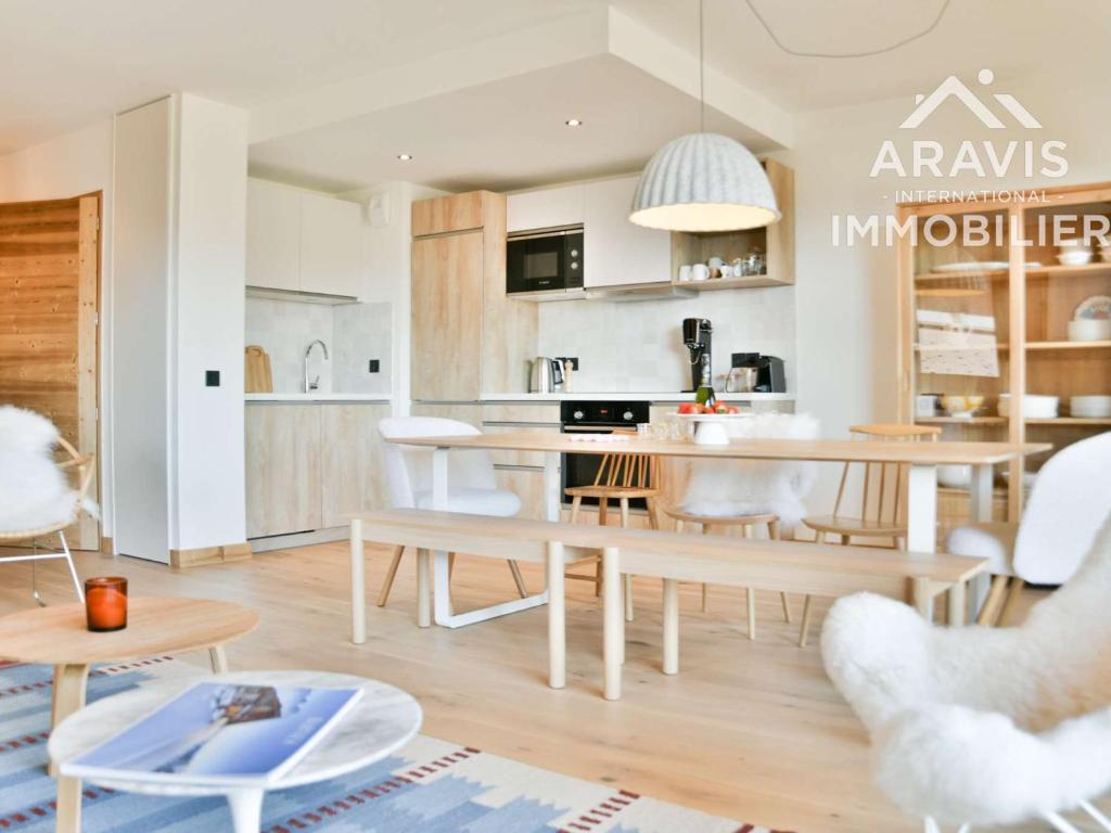 une cuisine et un salon avec une table et des chaises dans l'établissement Appartement 3 chambres, terrasses, proche randonnées - FR-1-391-212, au Grand-Bornand
