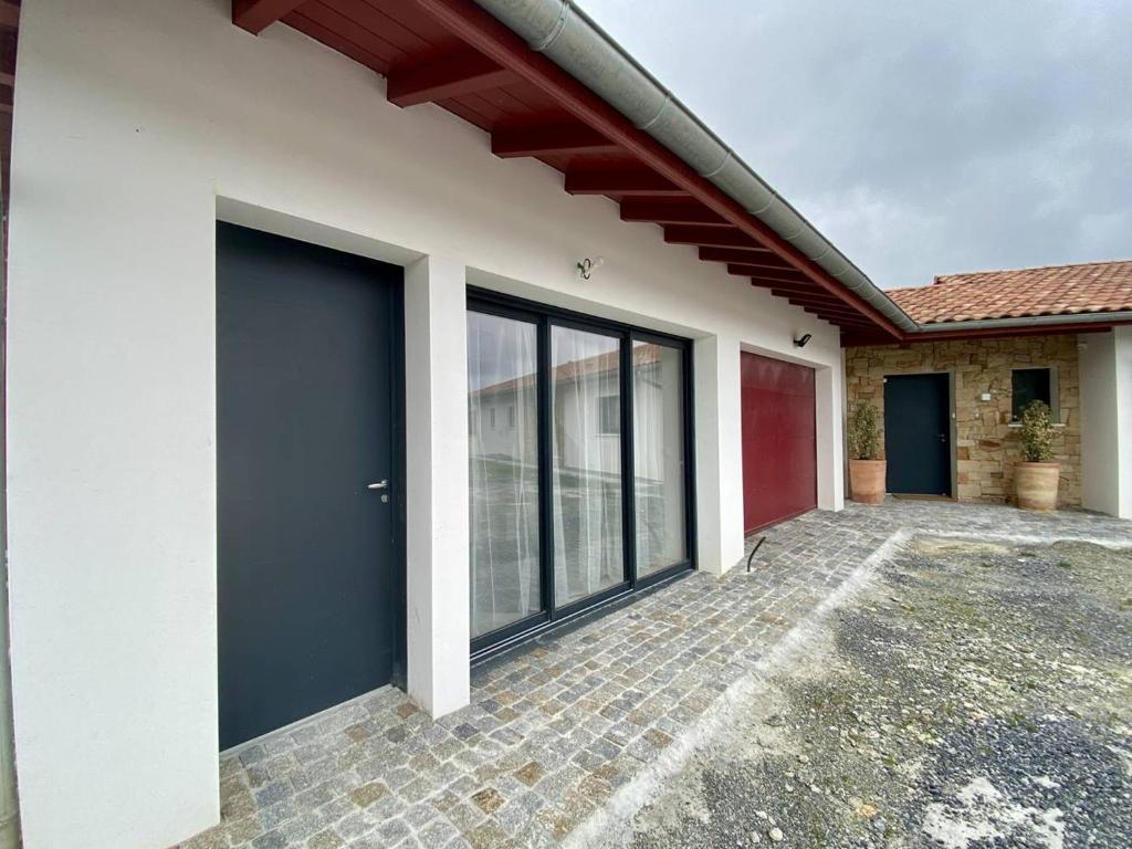 une maison avec une grande porte sur son côté dans l'établissement Cambo-les-Bains : T1 Bis cosy avec jardin et WiFi - FR-1-495-149, à Cambo-les-Bains
