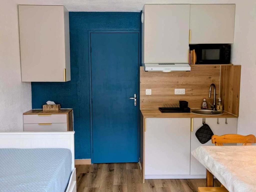 une porte bleue dans une petite cuisine avec un évier dans l'établissement Studio cosy 4 pers à Châtel avec terrasse et parking - FR-1-676-221, à Châtel