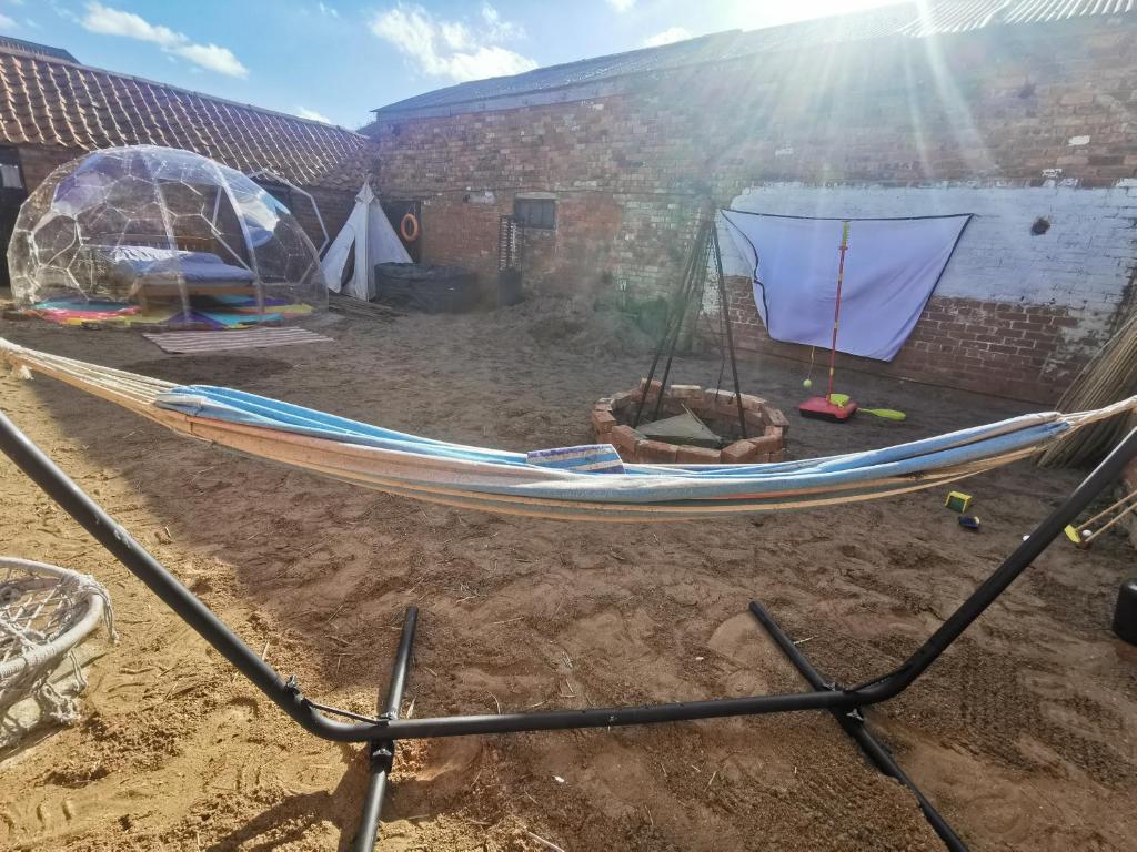 una hamaca en un patio con una tienda de campaña en Beachlife Dome with Hut & Hot Tub in Private Courtyard, en Snelland