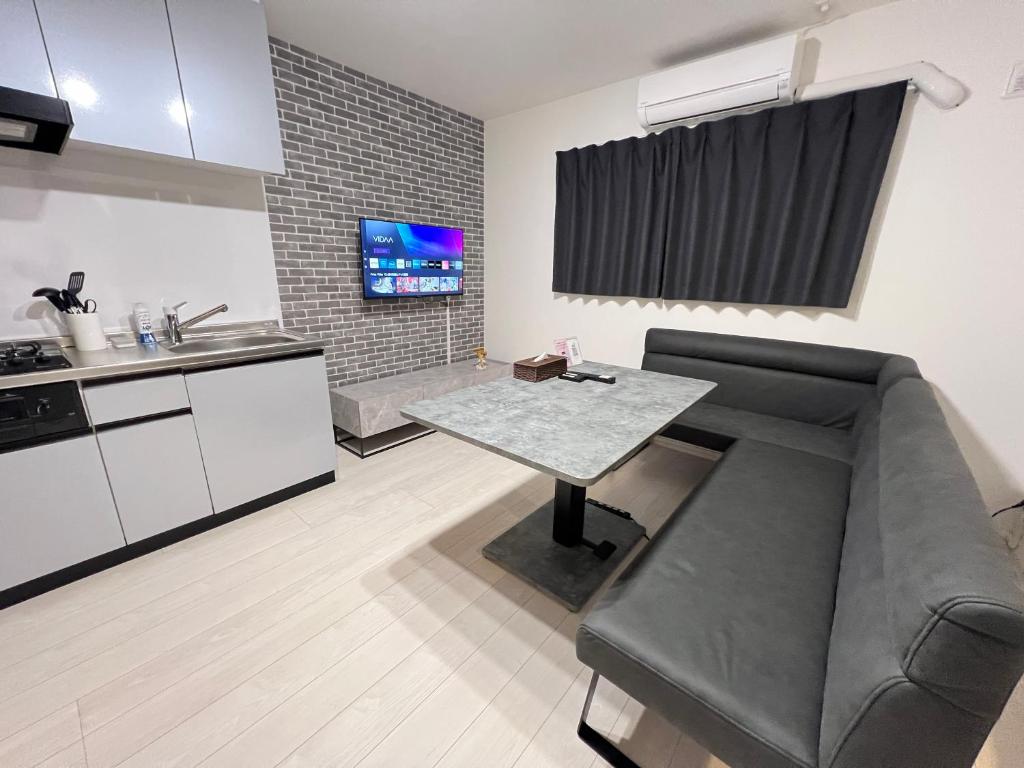 a living room with a couch and a table at ブレイブベース糸島 in Itoshima