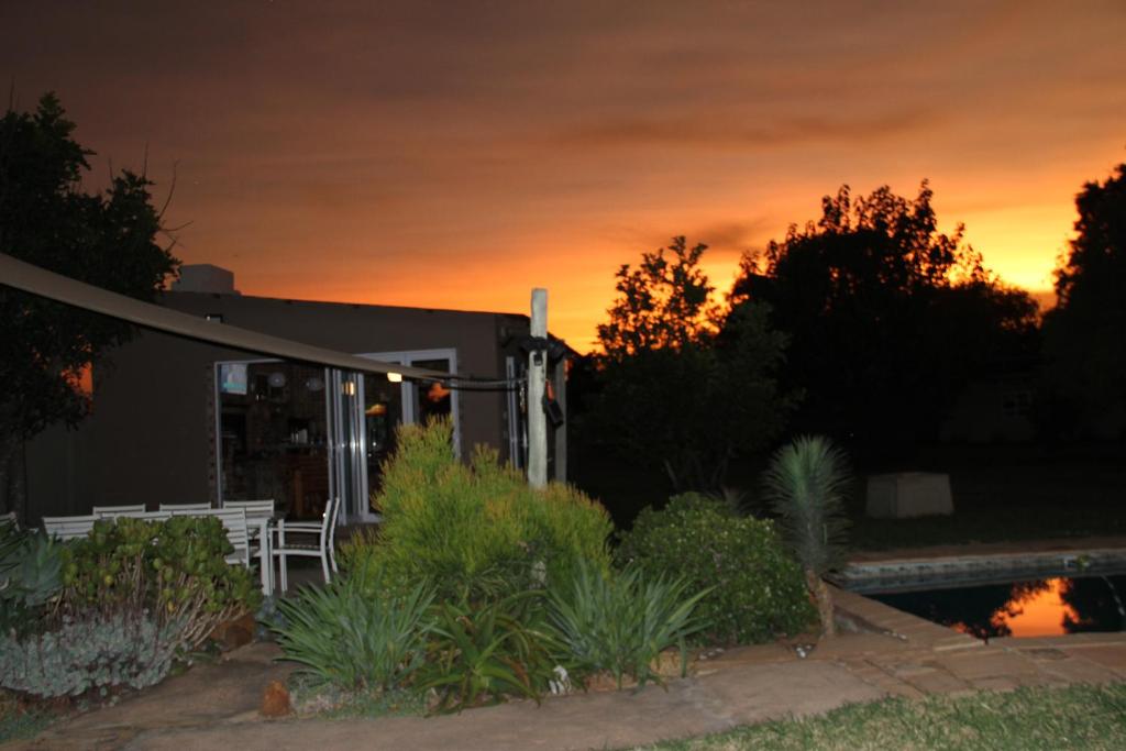 una casa con un tramonto sullo sfondo di 46 Welgevonden in Dinokeng a Dinokeng Game Reserve