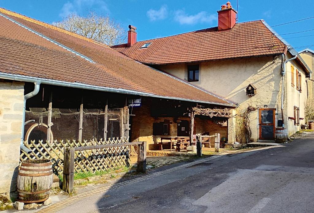 un vieux bâtiment avec une clôture devant lui dans l'établissement Les Gîtes Du Larderet, à Le Larderet