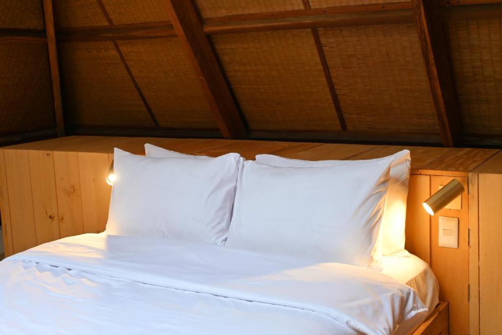 a bed with white sheets and pillows in a room at Julita Boutique Villas in Burgos