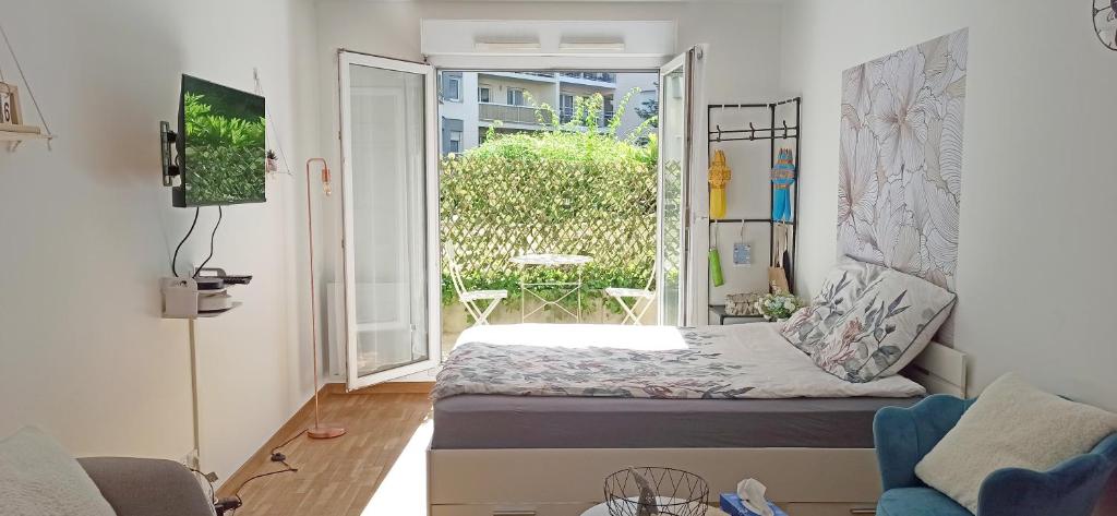Cette petite chambre comprend un lit et un balcon. dans l'établissement Petite Touche Douceur - avec parking et terrasse proche La Défense, à Suresnes