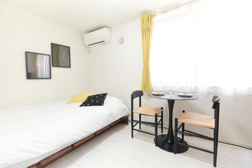a small room with a bed and a table at Fontaine Kamata by Tranova in Tokyo