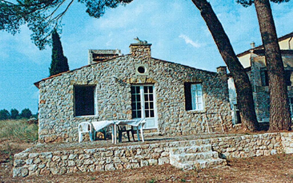 une maison en pierre avec une table en face dans l'établissement Le bastidon le pavillon, à Fox-Amphoux