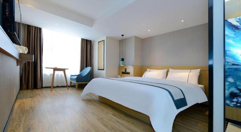 a hotel room with a large bed and a television at City Comfort Inn Guiyang North High Speed Railway Station in Guiyang