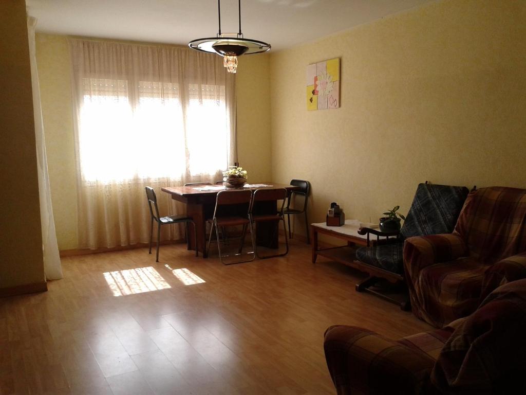 sala de estar con mesa, sillas y ventana en Can Mestre, en Cambrils