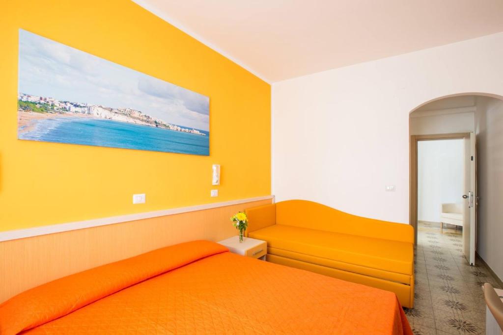 una camera con un letto arancione e una parete gialla di Le Bouganville a Vieste
