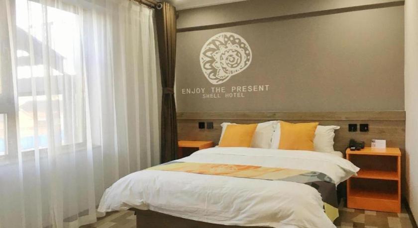 ein Schlafzimmer mit einem Bett und einem Schild an der Wand in der Unterkunft Shell Hotel Beijing Miyun District Shuiku Yangguang in Xiwengzhuang