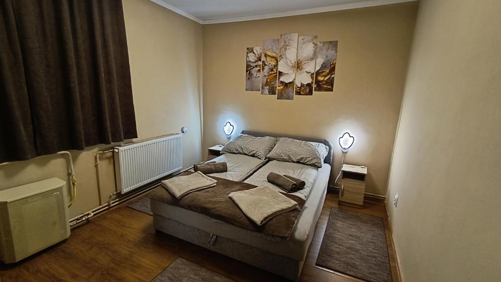 Un dormitorio con una cama y dos lámparas y una ventana. en DebRentZen Station Apartman - business plus, en Debrecen