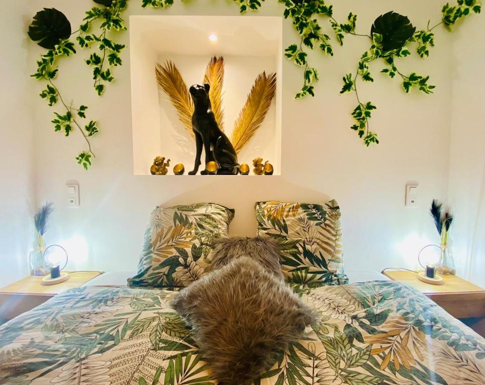 une chambre avec une statue de chat assise sur un lit dans l'établissement Ici, dort un Gorille, à Planay